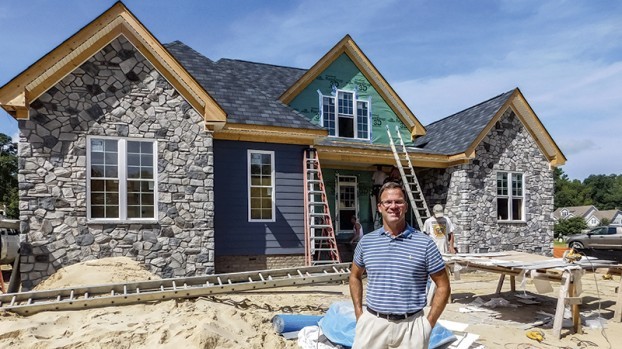 Mark Edwards in front of home under construction