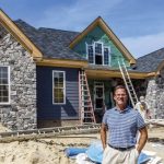 Mark Edwards in front of home under construction